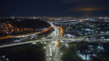 Hyperlapse shot over the lively wharf with heavy traffic along the bridge. Drone footage of the metropolis, vividly illuminated at night. High quality 4k footage