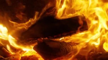 Wooden log in fire place inside family house creating cozy atmosphere on winter holidays season. Family gathering, Winter vacation concept, copy background. Scenic bright flame burning in slow motion
