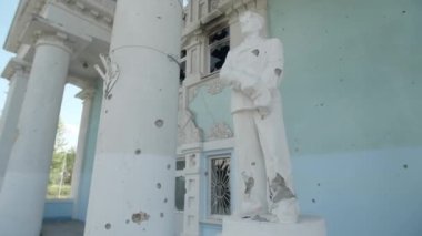 Mart 2022. Bucha, Ukrayna. Rusların Kyiv 'in banliyölerini istila etmesinden sonra harap oldu. Sütunları olan güzel bir binanın önündeki eski heykel. Yüksek kalite 4k görüntü