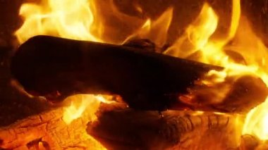 Ateş ve alevlerin yavaş çekim videosu. Şömine yanan ahşap odunlar ya da alevlerle benzin yanıkları. Alevler ve yanan kıvılcımlar, yakın çekim, ateş desenleri. Fotokopi uzayı ile karanlığın içinde cehennem ateşi.