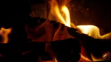 Blazing campfire in cozy mountain cabin on dark evening. Bonfire background dolly shot on RED camera. Burning wood on romantic evening, copy space background for relaxation, meditation footage