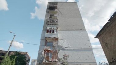 Mart 2022. Irpin, Ukrayna. Rus füze bombardımanından sonra yıkılan konut binası. Kırık camların alçak açılı görüntüsü ve bombalanmış balkonlarla dolu tuğla cephe. Yüksek kalite 4k görüntü