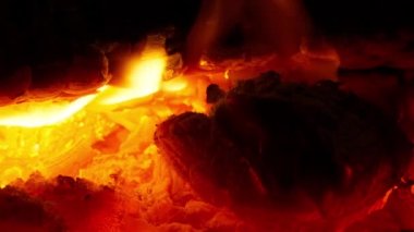 Siyah arka planda ateş alevlerinin çok yavaş hareket etmesi. RED sinema kamerasıyla çekildi. Aile toplantısı için sıcak bir ortam ve aile etkinliği için kış mevsiminde sıcak bir yer.