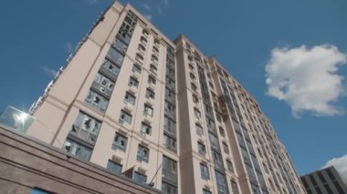 March, 2022, Bucha, Ukraine. Destroyed residential building after the invasion. Broken windows at facade with clear blue, vivid skyline in the background. High quality 4k footage