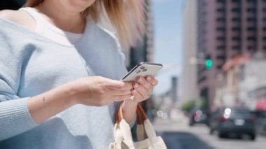 Modern şehrin merkez iş bölgesindeki akıllı telefondan hareketli arka planda başarılı bir genç kadın internette geziniyor. RED bağlantısı, sosyal medya, iletişim konsepti üzerine sinematik yakın çekim