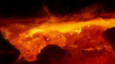 Sıcak şöminede kıvılcımlar yanan parlak turuncu ateşin 4K yavaş çekim klipsi. Sinema ateşinde yakacak odunların karanlık görüntüsü. Ev atmosferi kırmızı kamera görüntüsü ekran koruyucu arka plan videosu