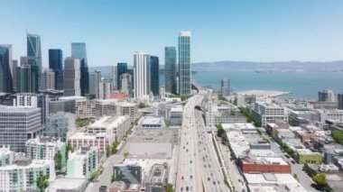 Scenic aerial footage of cars driving by highway to Bay Bridge at cinematic cityscape. Traffic highway transportation. Skyscrapers buildings at downtown streets. Business center of San Francisco, USA