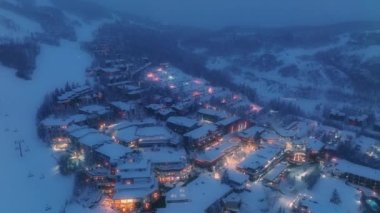 Aerial cottages in winter forest. Cozy Wooden Chalet Houses in Aspen. Christmas atmosphere. Snowing Snowfall. Glowing Christmas tree. Christmas spirit and New Year. Xmas Wallpaper 4K Snowmass resort