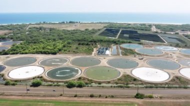 Landfill aerial view on Kauai island, Kauai Hawaii, with scenic ocean views. Biological treatment of sewage in aeration tanks filled with activated sludge. Drone flying above industrial pools and road