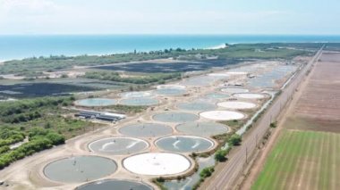 Ecology concept footage, water and land pollution industrial site. Global climate change due to consumerism. Processing plant with industrial ponds. Aeration station Hawaii. Aerial view from drone 4K