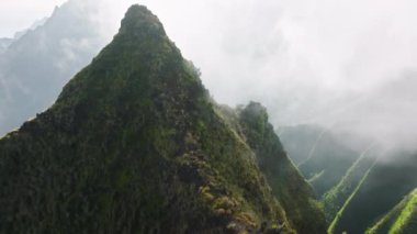 First person view over tropical jungle rocks. Drone view mountains on Napali coast nature park, Kauai island, Hawaii USA. Picturesque cloudy sky over Napali mountains. Drone flying in sunrise clouds