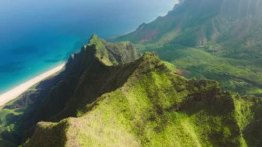 Breathtaking aerial view dramatic mountains, blue ocean on Napali Coast Kauai island Hawaii USA. Beautiful nature drone flying over green jungle mountain peaks revealing tropical beach on Na Pali park