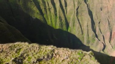 Kauai national park aerial 4K. Small helicopter flying in deep green mountain canyon, low above green jungle forest of Na Pali Coast National park. Sunny summer weather perfect for tourism flight USA