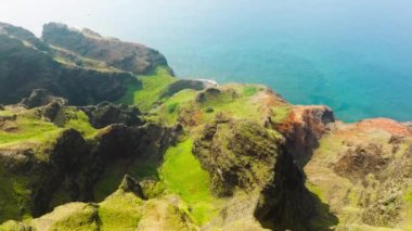 Aerial view flying over jungle mountain peaks revealing tropical coastline, Na Pali coast Kauai. Summer adventure trip on sunny Hawaii island with breathtaking nature. Copy space on nature background
