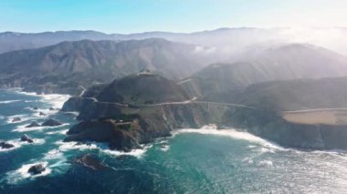 Drone footage of majestic seascape with pristine mountains in the background. Scenic highway along the cliff edges of Big Sur. High quality 4k footage