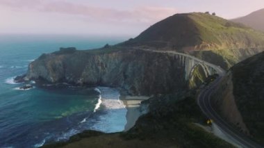 Aerial view of one of the highest bridges in the world, above the bottom of a steep canyon. Bixby Creek Bridge from its southern end. High quality 4k footage