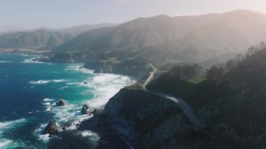 Bright fresh green on the hills, washed with blues ocean waters. Aerial footage of stunning morning fog floating above the mountains and creek. High quality 4k footage