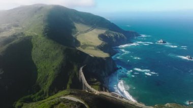 Stunning surroundings of Bixby Creek Bridge with morning fog above the mountains. Drone footage of coastal wilderness in Big Sur, California. High quality 4k footage