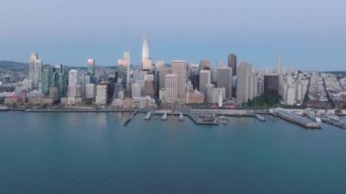 The cluster of high-rise towers surrounded by the natural harbor of the city. Aerial footage of Downtown San Francisco with massive skyscrapers and impressive skyline. High quality 4k footage