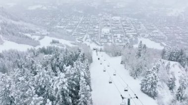 People riding ski lift and gondola. Skiing on snow slopes in mountains. People having fun on the slopes on a snowy day. Winter sport and outdoor activities on Christmas holidays. Ski holidays in Aspen
