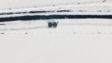 Winter roads cleaning in Colorado. Truck cleaning snow. Snowplows in North America. Snow removal truck on the roads in Aspen and Snowmass villages. Aerial drone view on winter snowcat transportation
