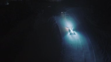Aerial shot 4K snow cat during night removing snow from skiing slope. Epic snowy mountains with Snow groomer. Skiing and snowboarding vacation in Aspen mountains ski resort. Pro snowcat transport