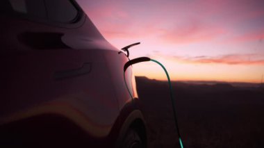 Electric car power charging, Charging technology, Clean energy filling technology. Graphic animation of light blue energy light beam moving in charging cord into electric car and charging battery RED