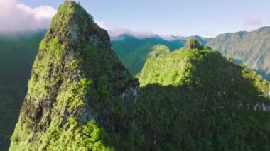 Epic nature landscape. Scenic aerial of Hawaii island on sunny summer day. Amazing views of green mountain peak in golden sunrise light. Clouds covering tropical jungles on motion background.USA drone