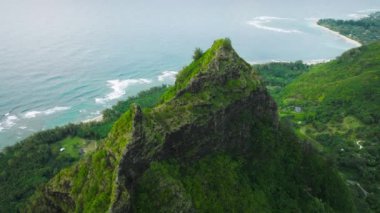 Aerial view of emerald-hued cliffs with razor-sharp ridges tower above the Pacific Ocean. Beautiful beaches and rocks that plummet to the lush valley floor. High quality 4k footage