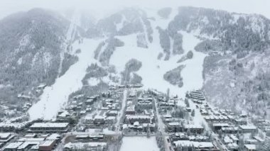 Aerial Aspen town view Mountain chalets in ski resort area with snowy slopes on winter day. Christmas holidays, winter travel vacation, people skiing. Winter Holidays in Aspen village in Colorado USA