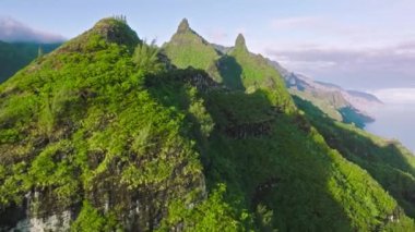 Cinematic nature drone shot on epic Hawaii island. Paradise tropical view with high green peaks highlighted by golden summer sun. Beautiful jurassic world park nature at sunrise, Na Pali coast park 4K