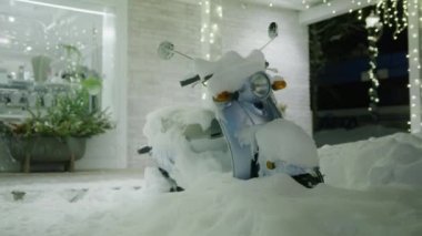 Winter wonderland background in slow motion shot on RED camera. Christmas holidays vacation footage with small town village covered with fresh snow. Stylish old fashioned moto scooter under white snow