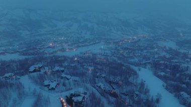 Night illumination in world famous mountain ski resort village travel destination of wealthy Americans family for the winter Christmas holidays. Aerial view Aspen Snowmass Ski Resort village at night