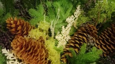 Slow motion close up view Christmas tree decorations with snowflakes and large fir cones. Stylish Christmas background for sales offer, promo sale copy. Green Christmas tree footage shot on RED camera