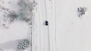 Snow removal truck on the roads in Aspen and Snowmass villages. Aerial drone view on winter snowcat transportation. Roads in winter Colorado. Car for cleaning snow. Snowplows in North America, USA