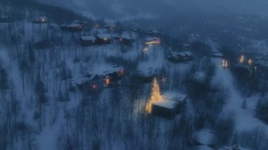 Xmas Wallpaper 4K Snowmass resort. Aerial cottages in winter forest. Cozy Wooden Chalet Houses with decorated Christmas tress outdoors in Aspen. Snowy Glowing Christmas trees. New Year atmosphere