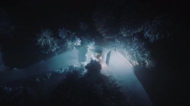 Geceleri karlı dağlarda sinematik gece havası. Kar kedisi gece taze karı temizliyor. Colorado Dağları 'nda kış. Noel 'de Aspen ve Snowmass Village kayak merkezinin 4K insansız hava aracı görüntüsü