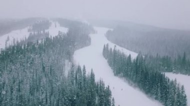 Soğuk kış gününde Colorado hava durumu. Kış turizmi 4K görüntüleri. İnsanlar tepeden kayak sandalyeleri ve manzaralı köknar ormanlarıyla kayak yapıyor. Noel tatili Aspen bölgesindeki Kar Topluluğu kayak merkezinde.