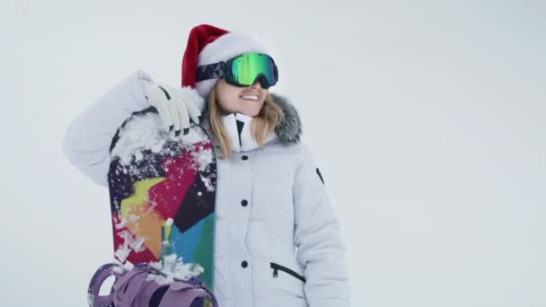Молодая Улыбающаяся Женщина Фотографирует Лыжном Склоне Красной Шляпе Санта Клауса — стоковое видео