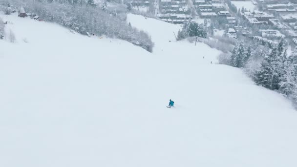 冬のスポーツやレクリエーション 冬の観光休暇 クリスマス休暇 ドローンカメラの下の大きな山の中で理想的なスキー場でのスキーのスローモーション空中映像 冬の野外活動 — ストック動画