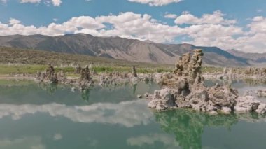 Mavi ufuk çizgisinin altındaki eşsiz mineral kaya oluşumlarının havadan görünüşü su yüzeyine yansıyor. Yosemite, California, ABD yakınlarındaki göz kamaştırıcı tufa kuleleri. Yüksek kalite 4k görüntü