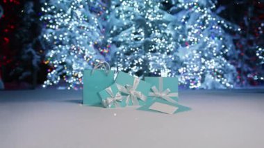 Mavi Noel ağaçlarına düşen kar gibi parlayan altın parçacıkları Mutlu Noeller kopyasıyla parıldayan ışıklar. Karlı bir yer. Mutlu Noel metinleri. Düşen kar taneleriyle büyülü kış arkaplanı üzerine.