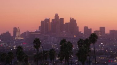 Los Angeles 'ın Los Angeles şehir merkezindeki bulanık arkaplanda çekilmiş sinematik defocus görüntüleri. Şehir silüeti ve gökdelenler manzaralı pembe gün batımından önce, ABD rüya manzarası