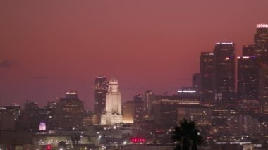 Los Angeles şehir merkezindeki Kızıl Kamera 'da panoramik bebek görüntüsü. Gökdelenlerin sinematik pembe günbatımı arkaplanındaki görüntüsü. Mali ve konut binaları şehir manzarası, LA USA video
