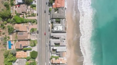 Gök mavisi suların yakınındaki köpüklü dalgalı evlerin hava görüntüleri. Pasifik Sahil Otobanı 'nın turkuaz deniz manzaralı manzarası. Yüksek kalite 4k görüntü