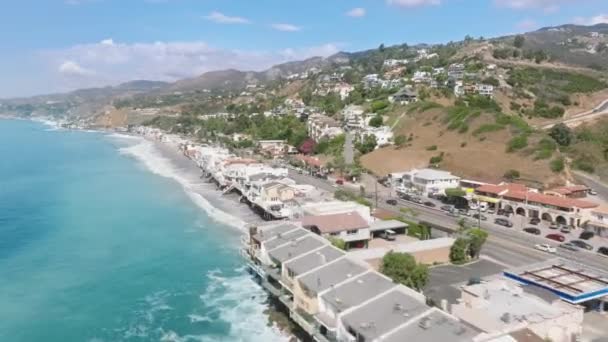 海岸の上に高くそびえる豪華なプロパティを持つ海沿いに広がる黄金の砂浜 カリフォルニア州マリブの絵のような近所の空中ビュー 高品質4K映像 — ストック動画