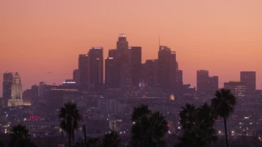 Los Angeles 'taki gökdelen binalarının ışıklandırılmış halleri. Gece vakti bulanık Los Angeles. Sinema pembe günbatımı gökyüzünde defocus içinde Amerikan şehri manzarası. Bulanık bokeh ışıkları arkaplanı