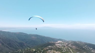 Adrenalin açık hava sporu. Malibu 'nun yukarısındaki doğada sakin ve güzel bir zaman. İki paraşütçü destansı yaz günışığında dağın tepesinde uçuyor. Paraşütler ya da yamaç paraşütleri ekstrem spor deneyimleri