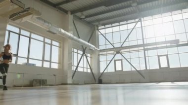 Neşeli bir sporcunun antrenmanına ve vücudunu güçlendirmesine yakından bakın. Kadın yoğun kapalı alanda idman yaparken ısınıyor. Yüksek kalite 4k görüntü