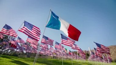Fransa 'ya uluslararası turizm ve iş seyahati kavramı, ekonomi. Fransa 'nın altın günbatımı arka planında rüzgarda dalgalanan kırmızı kamera görüntüsü, arkasında Amerika Birleşik Devletleri bayrakları